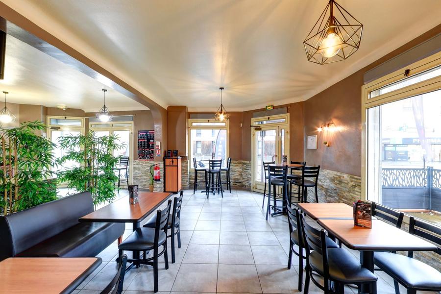 La salle : tables en bois, banquette, parement de pierre