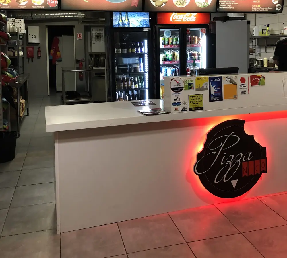 Le comptoir de Pizza N'Co Le Mans, avec le logo éclairé en rouge